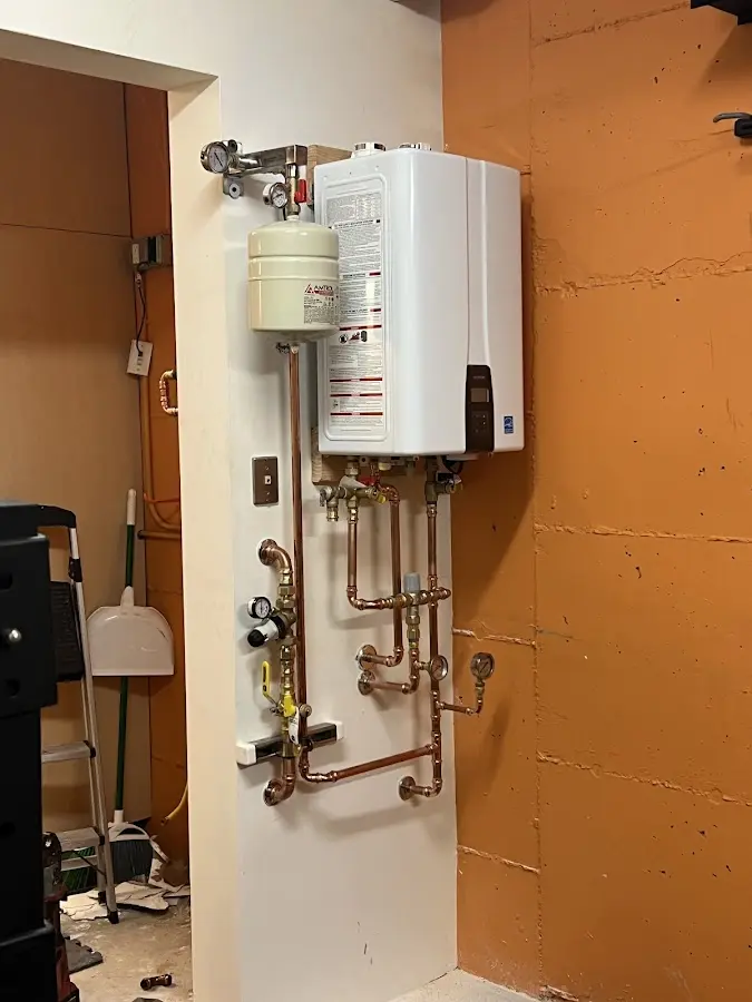 Plumbing technician inspecting water heater connections in Elkton